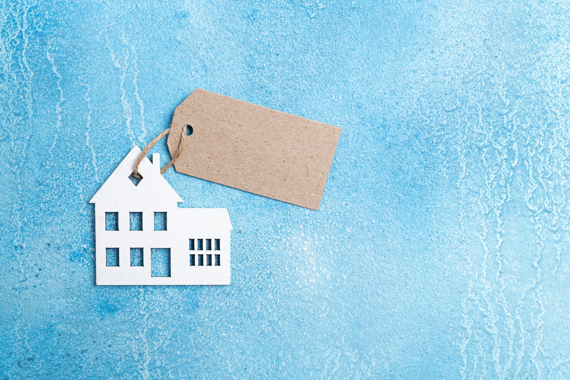 House for buy or rent label. Wooden house symbol with tag on blue background. Real estate