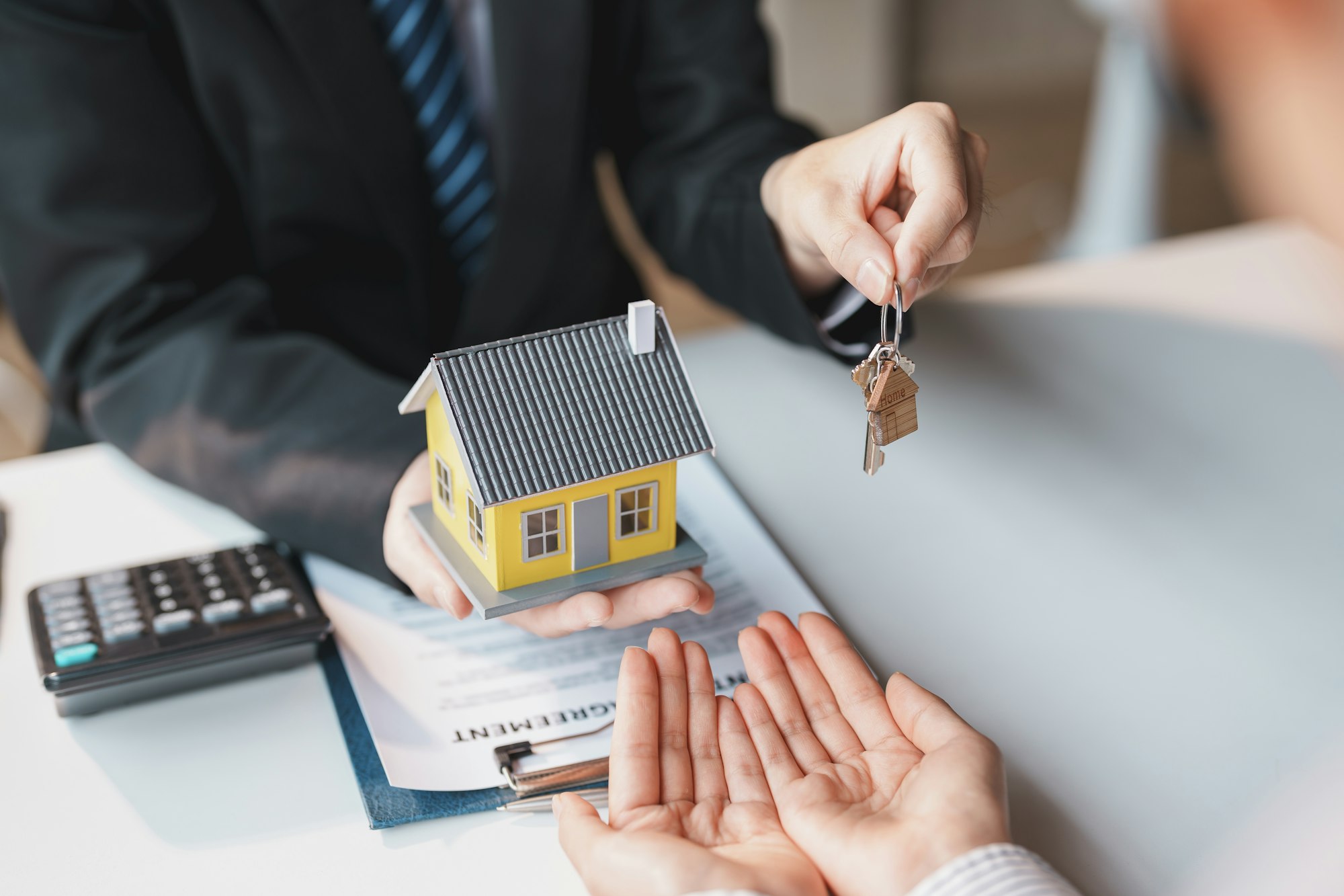 Real estate agent gives the couple the keys to the house after they sign the real estate sale contra