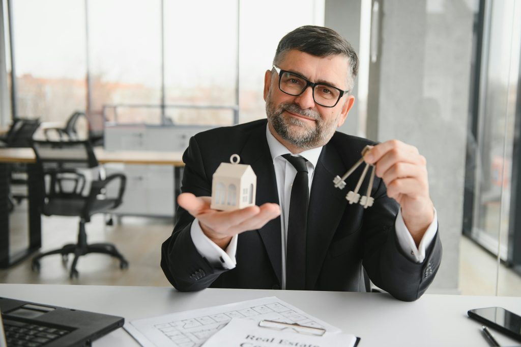 Real estate agent with house model and keys