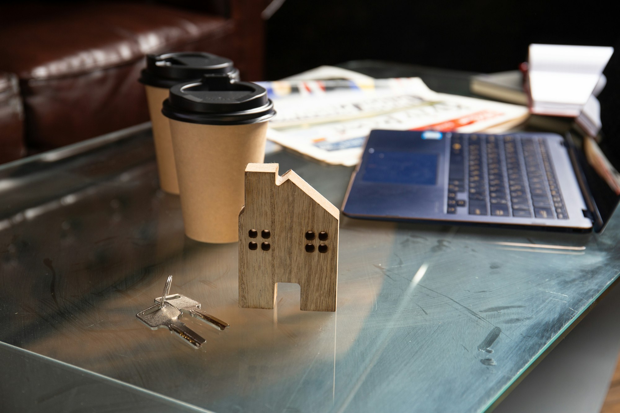 Workplace with laptop, diary, newspaper.